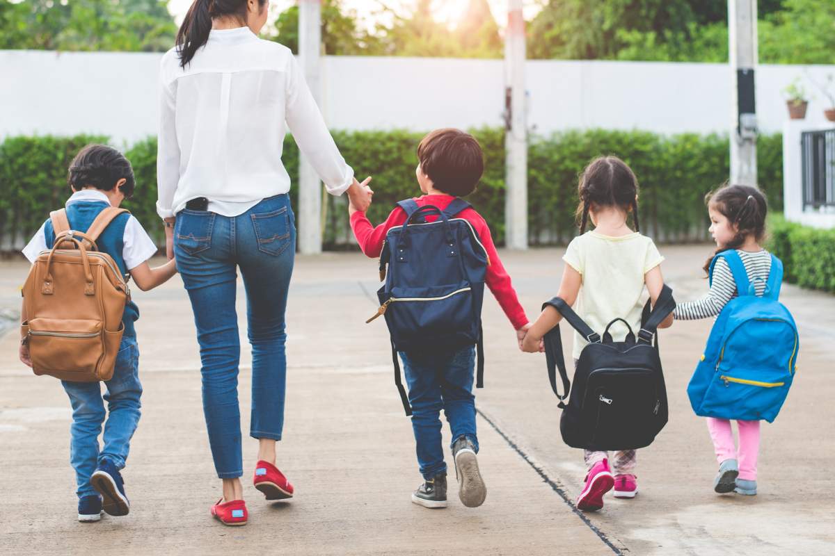 A picture of a parent holding her children's hands as they head back to school. This article will share the best and most important tips for parents when preparing for the new school year. From our physiotherapists at Prohealth Sports and Spinal Physiotherapy Centres Hong Kong